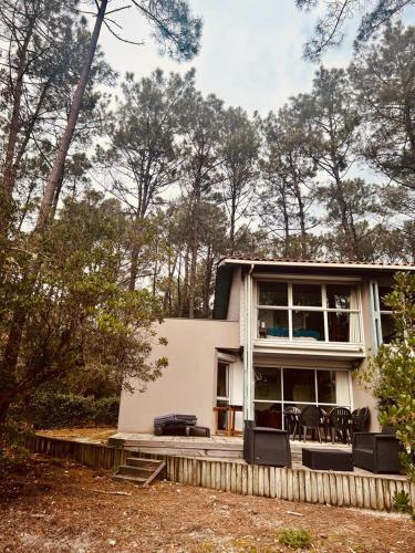 une maison avec des tables et des chaises devant elle dans l'établissement maison lacanau ocean, à Lacanau