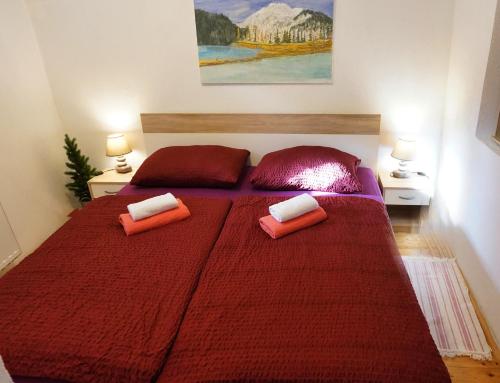 a bedroom with a large red bed with two pillows at Jacobs 4 Bedroom Private House in Kranjska Gora