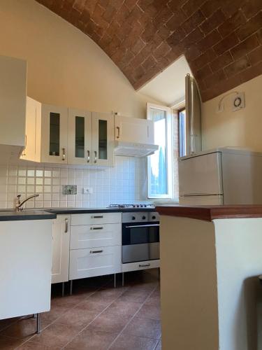 a kitchen with white cabinets and a stove top oven at CasaLeTolfe Residence in Siena