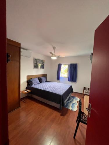 a bedroom with a bed and a chair in it at Pousada Bat N Breakfast No Beco do Batman in Sao Paulo