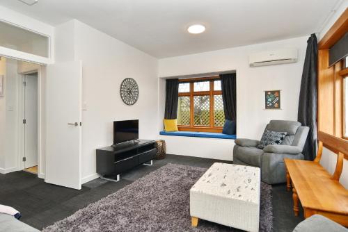 a living room with a couch and a tv at Grand Heritage 5 BRMs CBD villa with carparks in Christchurch