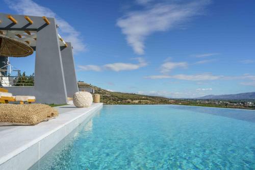 a swimming pool with a view of the water at Villa Capparis in Moírai