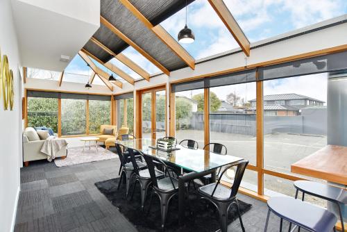 a living room with a glass table and chairs at Grand Heritage 5 BRMs CBD villa with carparks in Christchurch