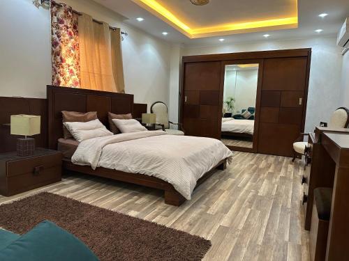 a bedroom with a large bed and a large mirror at Awesome Villa on a hill Families only in Cairo