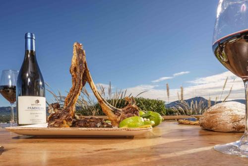 a table with a bottle of wine and a plate of food at Villa Capparis in Moírai