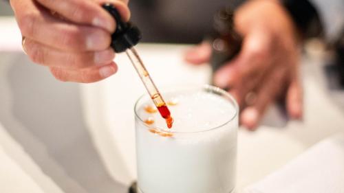 a person is stirring a drink with a stick at Illa Experience Hotel in Quito
