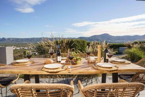 a wooden table with chairs and wine glasses on a patio at Villa Capparis in Moírai