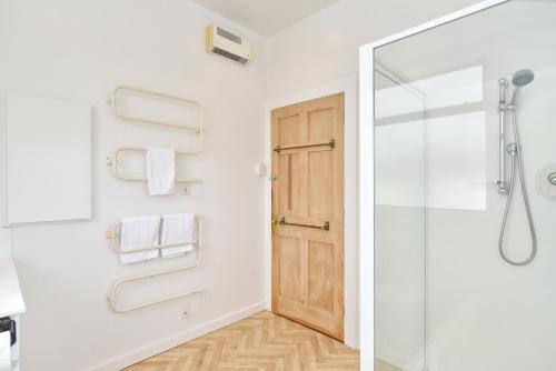 a bathroom with a shower and a glass door at Grand Heritage 5 BRMs CBD villa with carparks in Christchurch