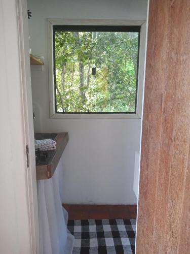 una ventana en una habitación pequeña con una habitación con suelo en Caza di Zaia - kitnet, en Búzios