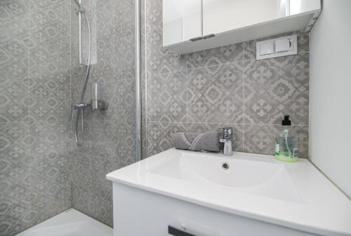格利維採的住宿－Apartament Modrzejewska，浴室配有白色水槽和淋浴。