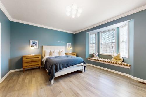a blue bedroom with a bed and two windows at Pine Crest in Pocono Pines