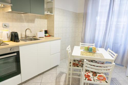 a kitchen with a table and chairs and a sink at Lingotto Luxury Apartment in Turin