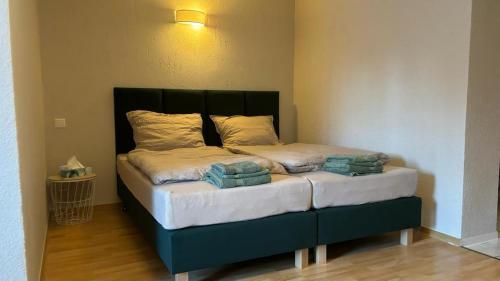 een bed in een kamer met een groen hoofdeinde bij Pension Altsprucke in Guben