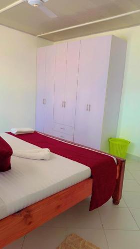 two beds in a room with white cabinets at Baali Diani Apartments in Ukunda
