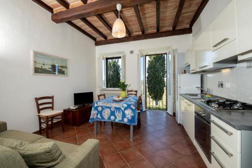 a kitchen and a living room with a table and a couch at CasaLeTolfe Residence in Siena