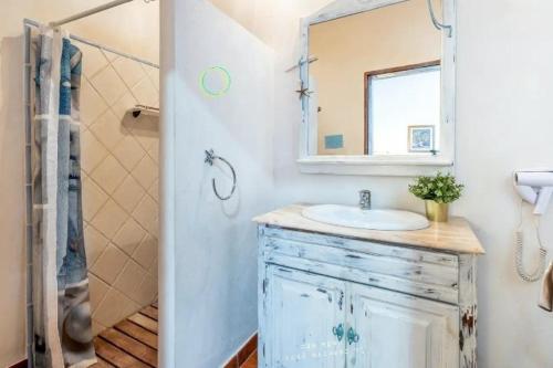 ein Bad mit einem Waschbecken, einem Spiegel und einer Dusche in der Unterkunft Ca sa Cristeta de s'escola in Sa Pobla