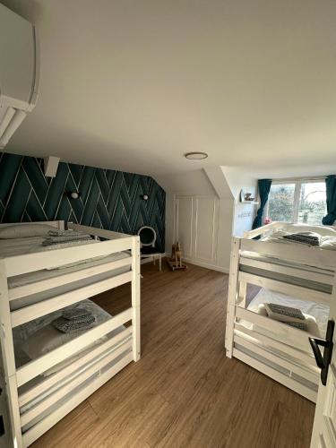 two bunk beds in a room with wooden floors at Maison spacieuse à Saint-Florentin, 138 m², avec jardin in Saint-Florentin