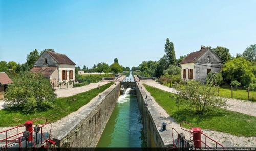 a canal in a town with buildings and a river at Maison spacieuse à Saint-Florentin, 138 m², avec jardin in Saint-Florentin