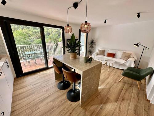 a kitchen and living room with a table and a couch at Apartamento Moderno con gran terraza" GREGAL" in Port de Soller