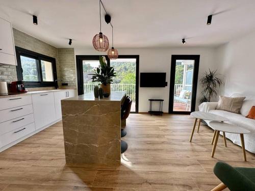 a kitchen and living room with a couch and a table at Apartamento Moderno con gran terraza" GREGAL" in Port de Soller