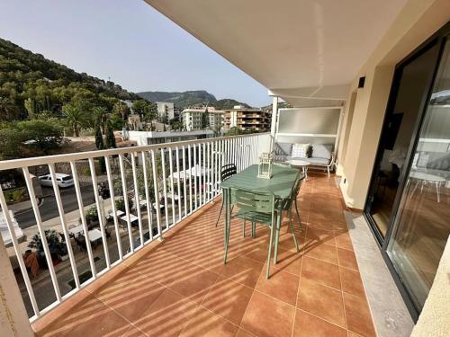 a balcony with a green table and chairs on it at Apartamento Moderno con gran terraza" GREGAL" in Port de Soller
