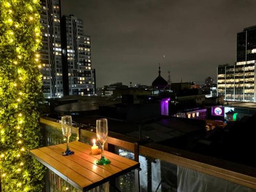 stół z 2 kieliszkami i świecą na balkonie w obiekcie Apartaestudio súper ubicado w mieście Bogota
