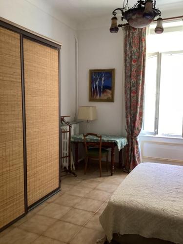une chambre avec un lit, une table et une fenêtre dans l'établissement Spacieux Appartement indépendant, à Cannes