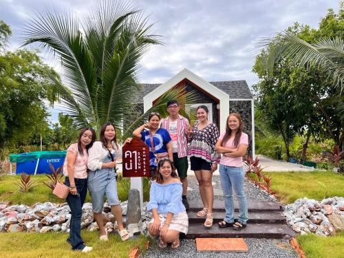 a group of people standing in front of a house at Cana Garden House 2 in Ban Khok