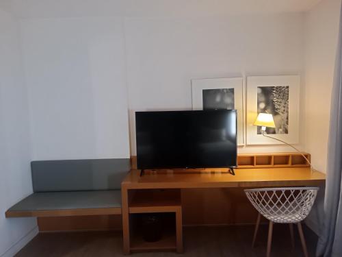 a desk with a flat screen tv on top of it at H2 Platinum Lourdes in Belo Horizonte