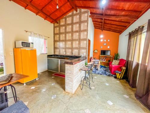 a kitchen with orange walls and a counter in a room at Casa Da Cléo Carrancas in Carrancas