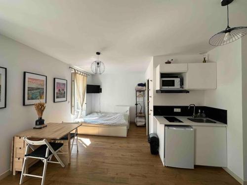 une cuisine et un salon avec une table et un lit dans l'établissement Guérande, studio entier intra-muros, à Guérande