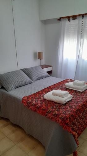 een slaapkamer met 2 handdoeken op een bed bij Apart Begonia, 1 dor con patio de luz in Río Cuarto