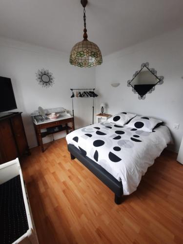 a bedroom with a bed with a black and white comforter at Soues in Soues