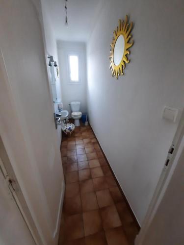 un couloir avec des toilettes et un miroir mural dans l'établissement Soues, à Soues