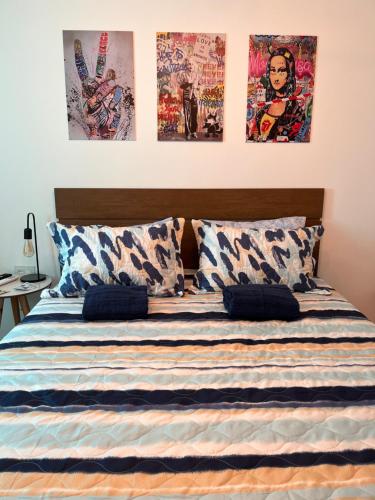 a bedroom with a bed with four posters on the wall at Pousada Bat N Breakfast No Beco do Batman in Sao Paulo