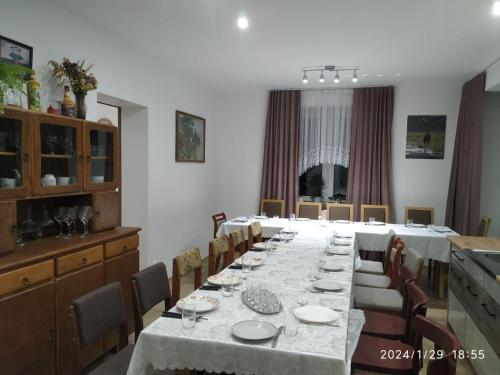 a large dining room with a long table and chairs at Dolistówka in Goniadz