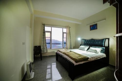 een slaapkamer met een groot bed en een raam bij Mom Blessing Homestay in Shimla