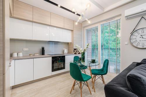 een keuken en een woonkamer met een tafel en stoelen bij VipWarsawApartments pl Sienna 65 in Warschau