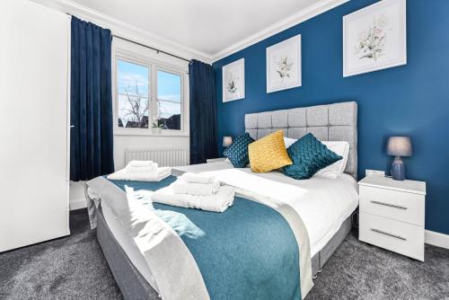 a bedroom with blue walls and a large bed at The Woodlands, shortstay, ideal for families, relocation, contractors, travel stay in Horley