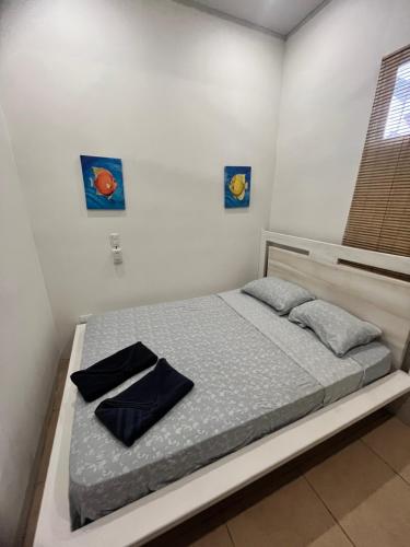 a bed in a room with two pictures on the wall at Casita Miss Sam en el Centro de Puerto Viejo in Puerto Viejo