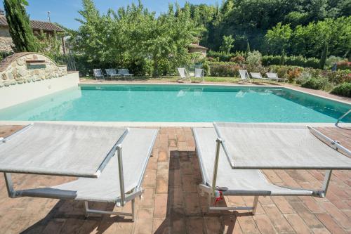 a swimming pool with two chairs and a table at Borgo da Vinci in Volterra