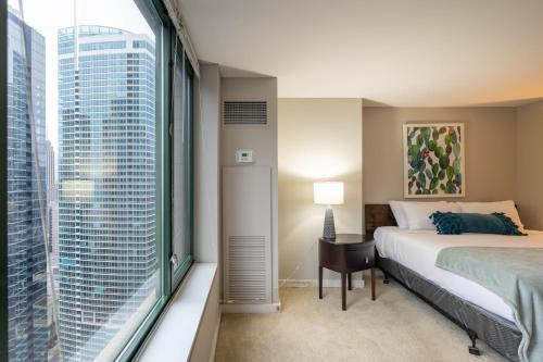 - une chambre avec un lit et une grande fenêtre dans l'établissement Captivating Apartment with Pier Views, Pool and Gym, à Chicago