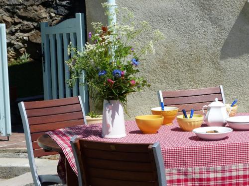 a table with a vase of flowers on top of it at Gite d'Appy in Les Cabannes
