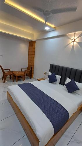 Un dormitorio con una cama grande con almohadas azules. en Hotel The Grand Jashi Residency, en Pātan