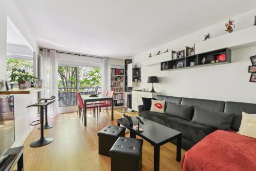 salon z kanapą i stołem w obiekcie Appartement design pour les amateurs de modernité w Paryżu