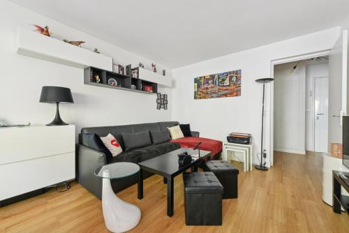 salon z kanapą i stołem w obiekcie Appartement design pour les amateurs de modernité w Paryżu