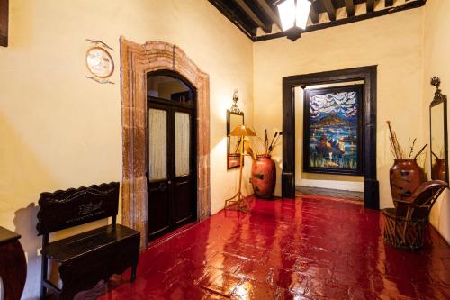 a living room with a clock on the wall at Hotel Mansion Iturbe in Pátzcuaro