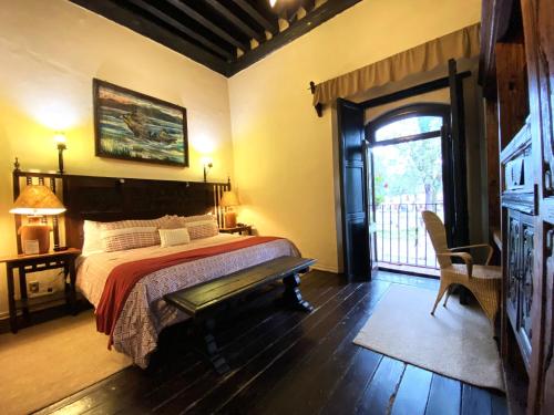 a bedroom with a bed and a door with a window at Hotel Mansion Iturbe in Pátzcuaro
