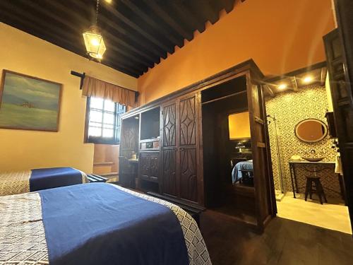 a bedroom with a bed with a blue bedspread at Hotel Mansion Iturbe in Pátzcuaro