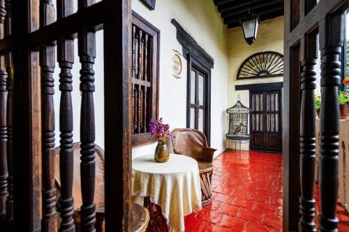 a room with a table with a vase of flowers on it at Hotel Mansion Iturbe in Pátzcuaro